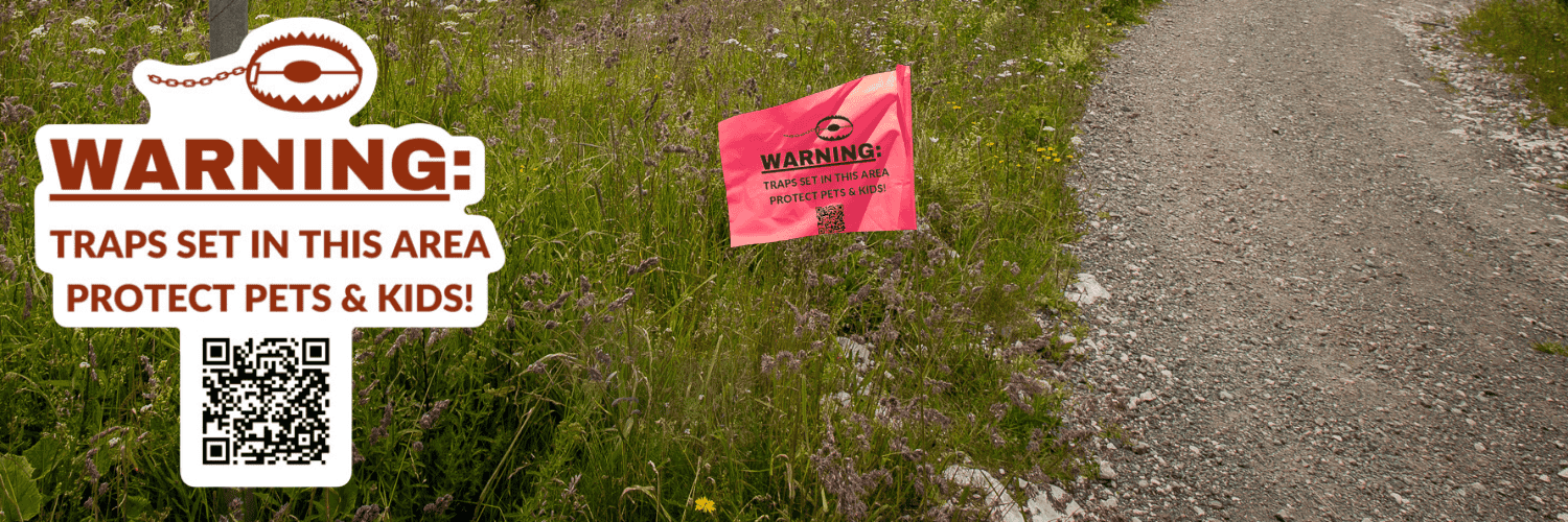 24.12.18 Trap Aware Banner2 An image of trail at the top of hill curving to the right and overlooking a forested valley below. In the foreground is a mocked-up image of a marking flag with an image of a trap at the top and a QR code at the bottom reads, "Warning: traps set in this area. Protect pets and kids."