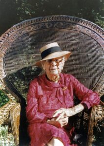 Majory Stoneman Douglas sits in a wicker chair wearing a pink suit and her signature broad-brimmed hat with a black ribbon. She is a trailblazer for women in conservation as we celebrate women's history month.