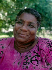 Hazel M. Johnson sits in a park with green trees behind her. She is a trailblazer for women in conservation as we celebrate women's history month.